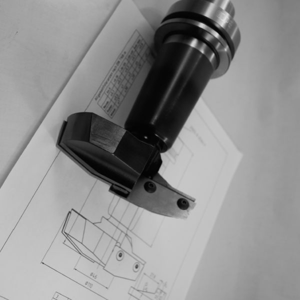 Black anodized CNC boring bar holder featuring adjustable boring head with precision adjustment screws displayed on detailed technical drawings