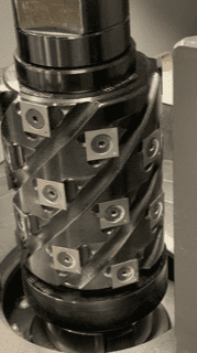 Spiral flute milling cutter with multiple carbide inserts arranged in helical pattern on cylindrical body for heavy-duty machining
