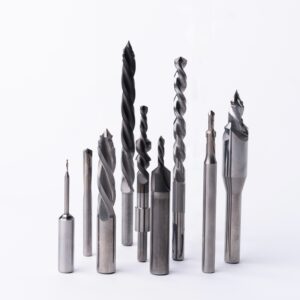 Professional metal drill bits and cutting tools set including twist drills, spade bits, and machining tools for metalworking and industrial applications arranged on white background