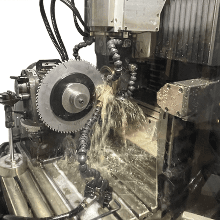 CNC machining center cutting metal gear with coolant spray and circular saw blade
